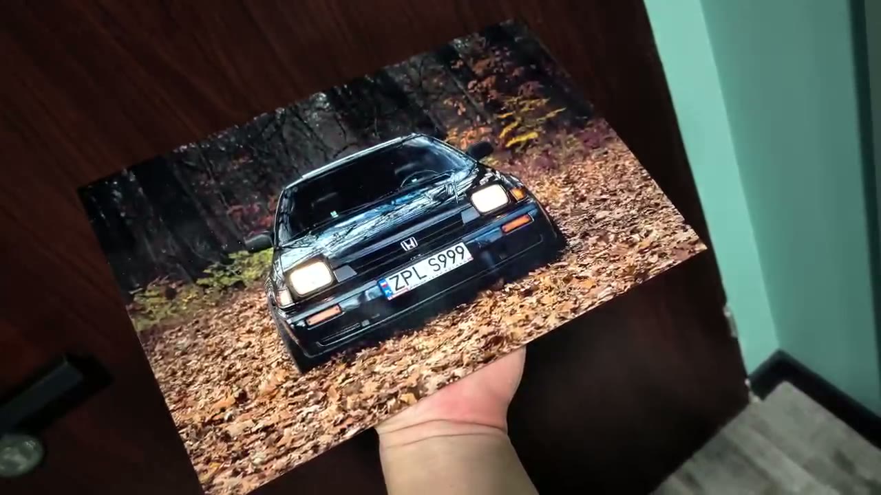 Metal poster 30×20 cm z Hondą w jesiennym lesie trzymany w dłoni