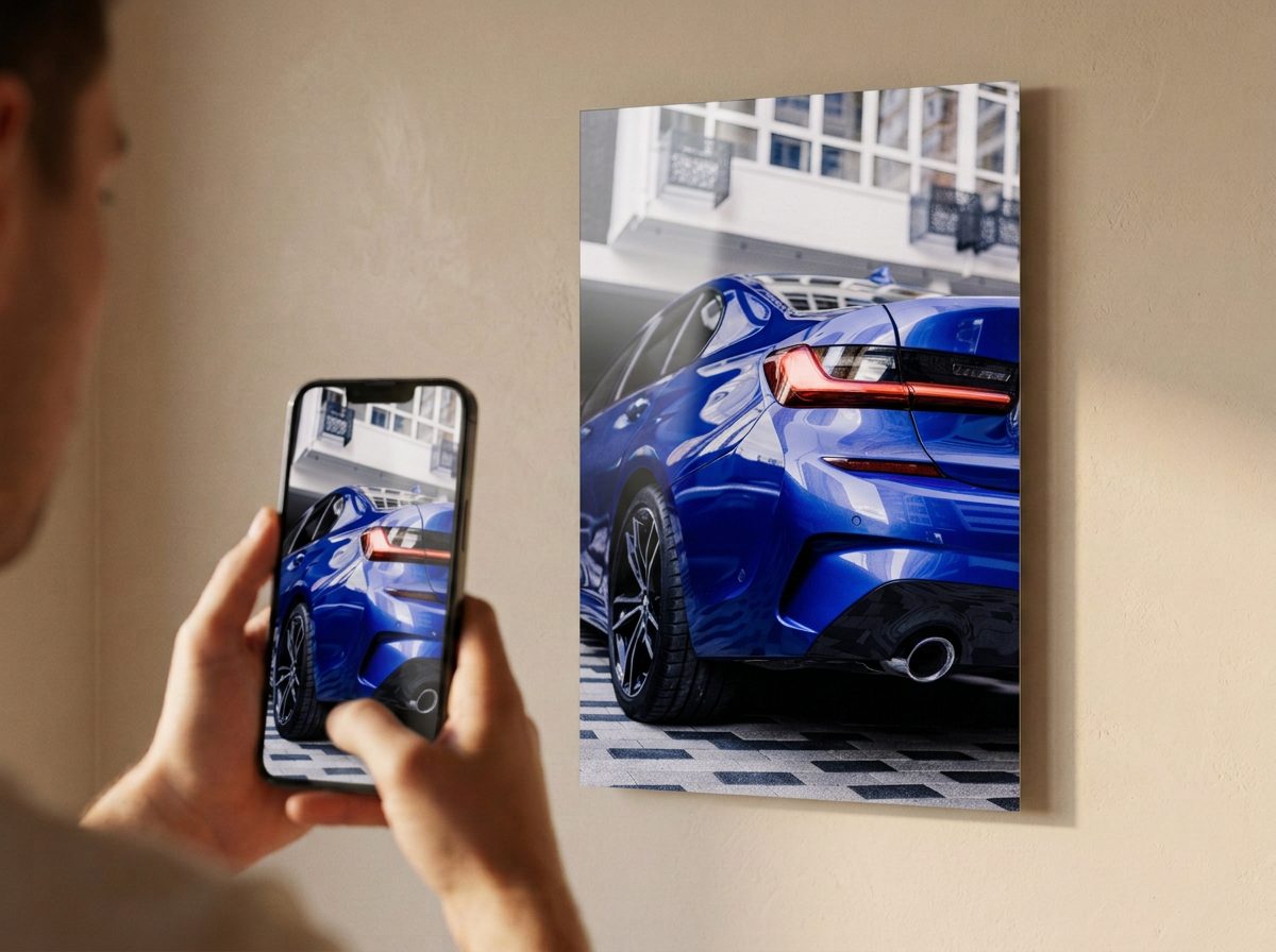 Dłoń trzymająca telefon ze zdjęciem auta, obok to samo zdjęcie jako metal poster na ścianie
